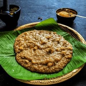 Chakkara Pongal/Sweet Pongal served in banana leaf with a cup of ghee on the side