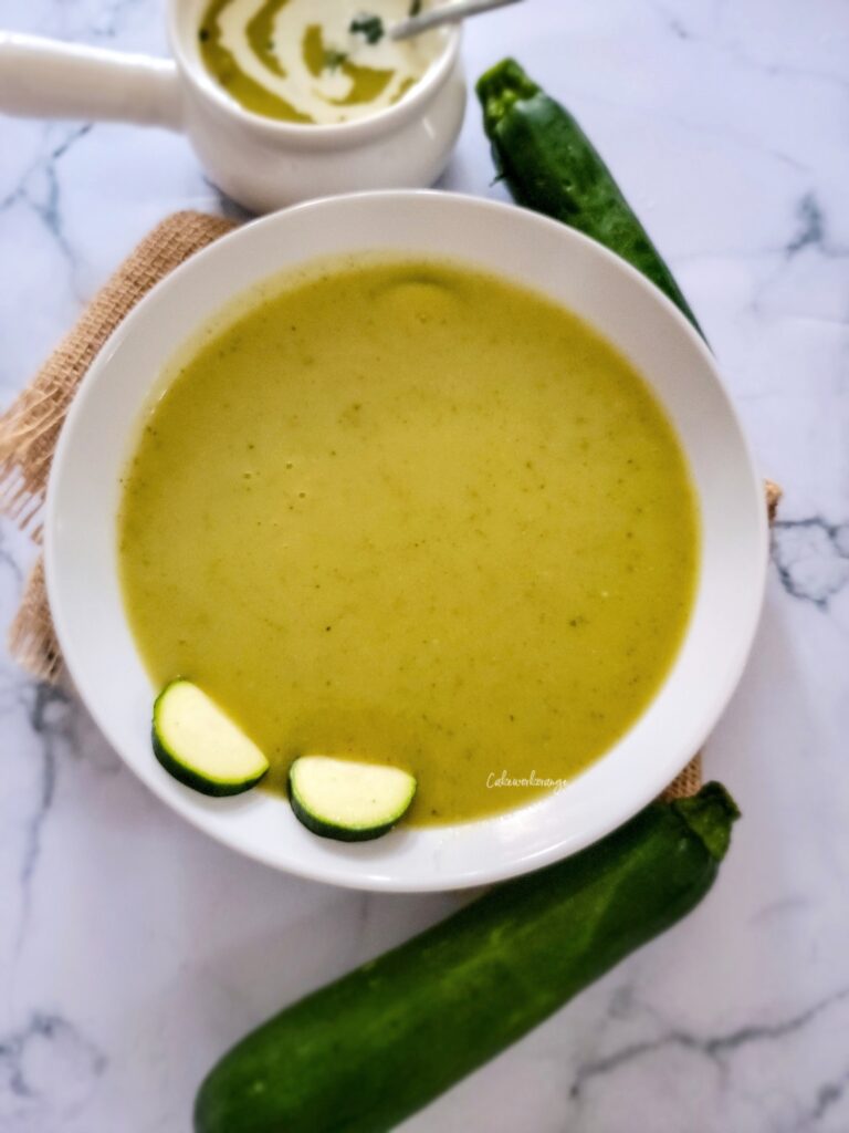 A bowl of zucchini potato soup topped with zucchini slices