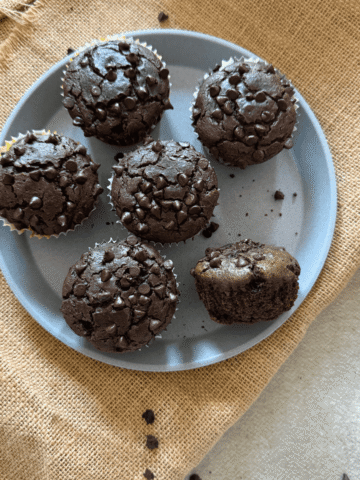 Soft ragi chocolate muffins topped with mini chocolate chips arranged on a plate