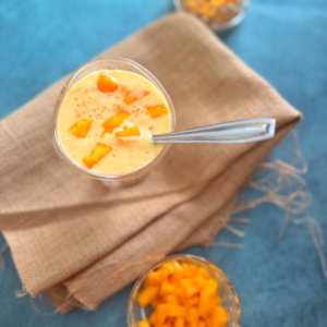 mango sago served in a glass bowl with a bowl of fresh mango pieces on the side
