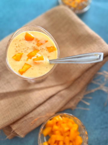 mango sago served in a glass bowl with a bowl of fresh mango pieces on the side