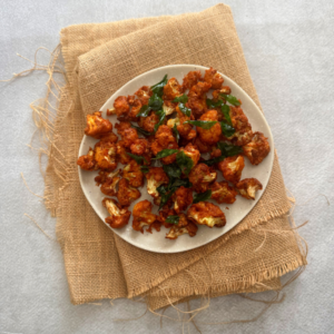 Crispy cauliflower 65 served with curry leaves garnish on a plate