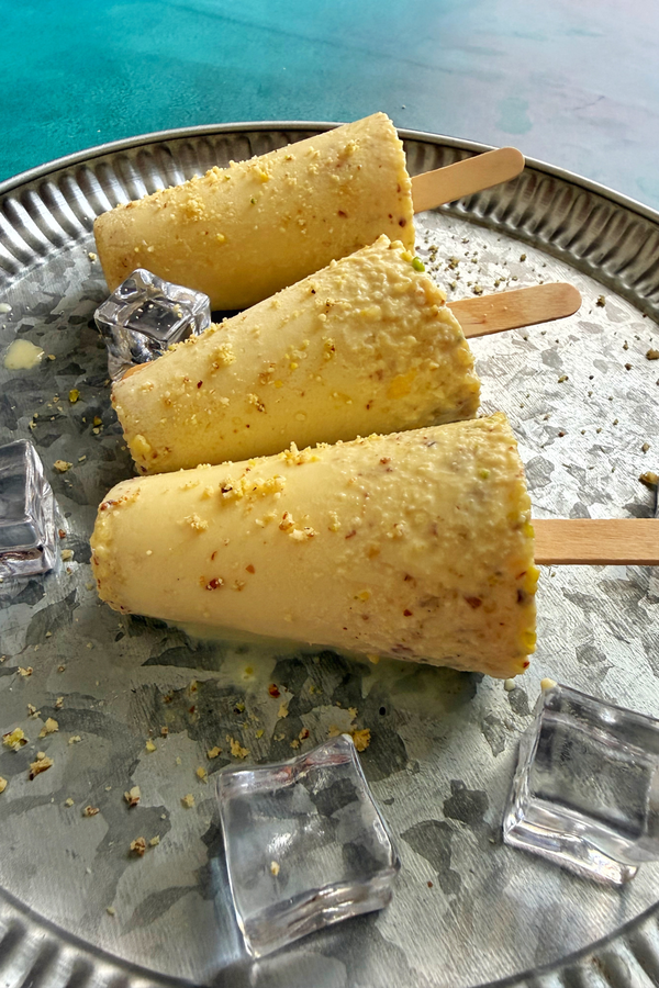 Rich and creamy kesar malai kulfi served on a plate with ice cubes