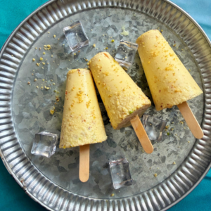 homemade malai kulfi garnished with finely powdered nuts served on a plate